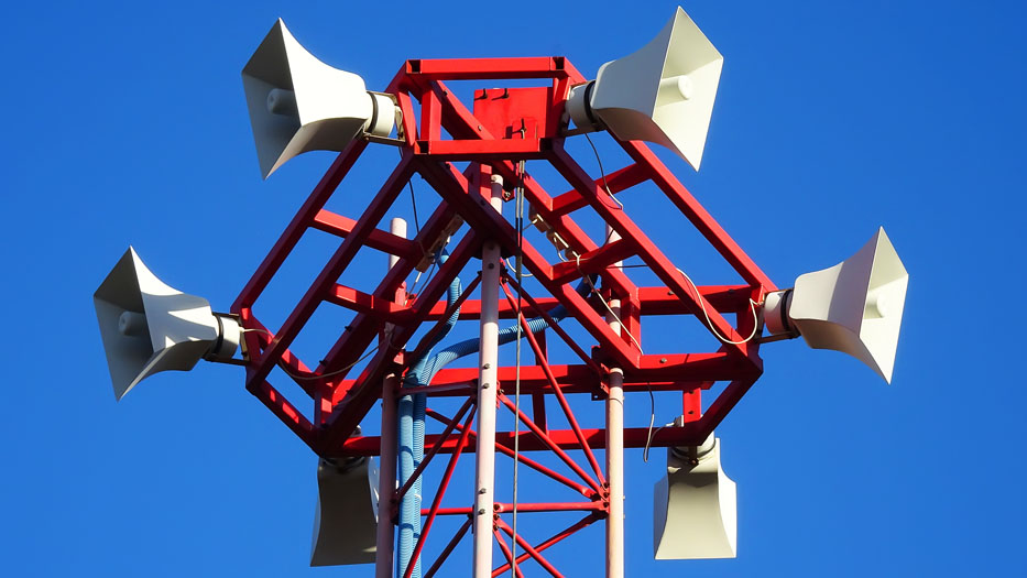 Rot-weißer Mast mit zahlreichen Lautsprechern / Sirenen